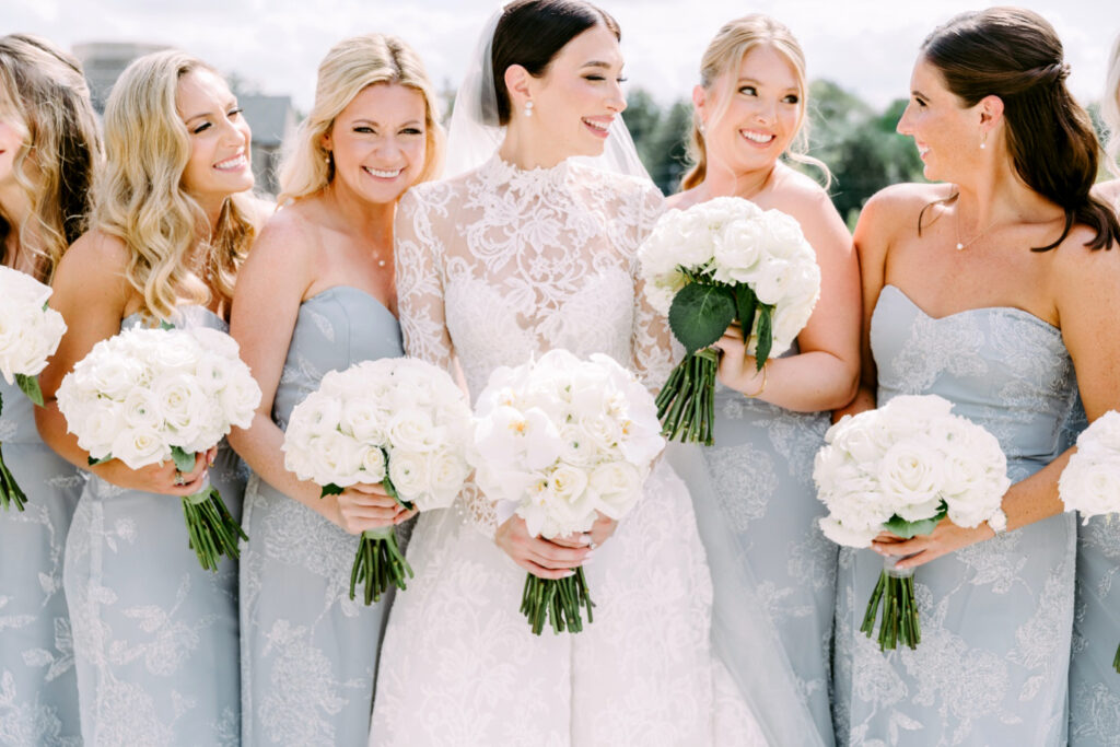 Villanova bride with her bridesmaids in light grey blue bridesmaid dresses holding white rose bouquets