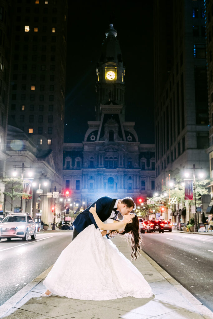 bride & groom portrait at night along Philadelphia's broad street in front of City Hall by Emily Wren Photography