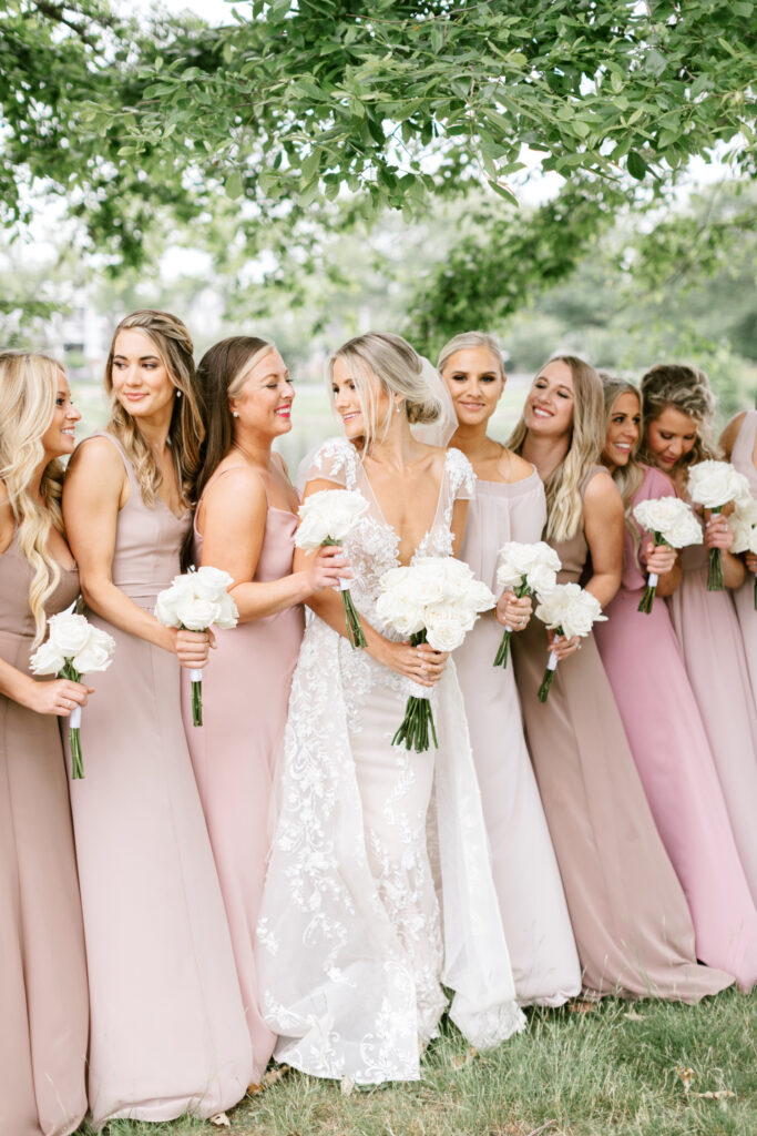 Spring Lake New Jersey bride with her bridesmaids in various shades of pink bridesmaid dresses