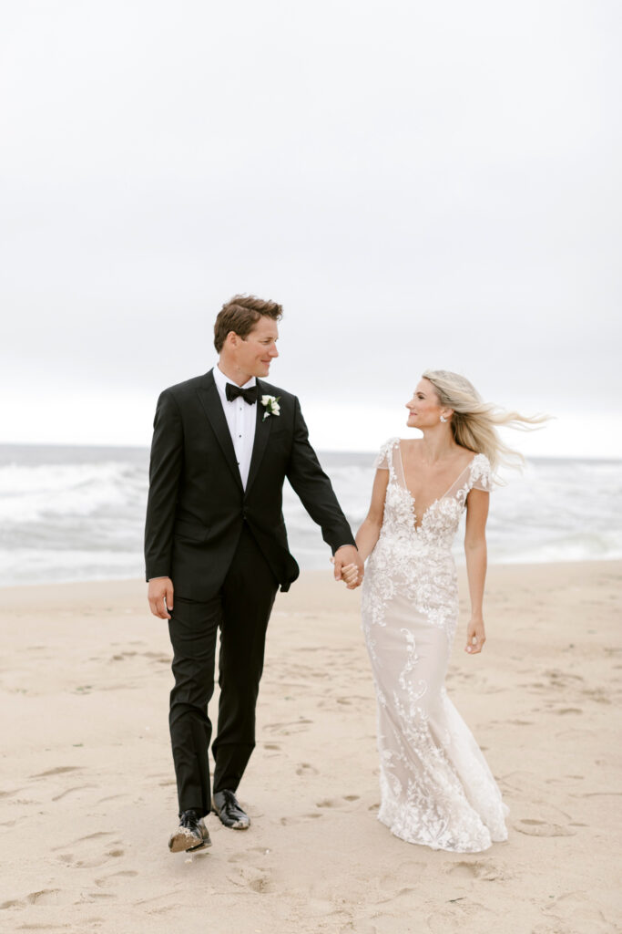 bride & groom walking along Spring Lake private beach by Emily Wren Photography