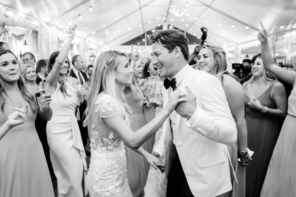 bride & groom dancing with their wedding reception guests under a white tent with string lights ini Spring Lake, New Jersey