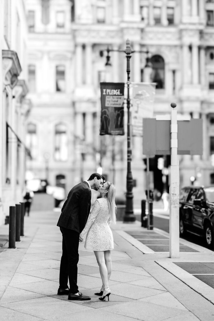 Couple kissing on Broad Street during their Philadelphia engagement photoshoot