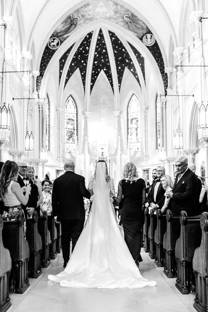 bride walking down the aisle with both of her parents