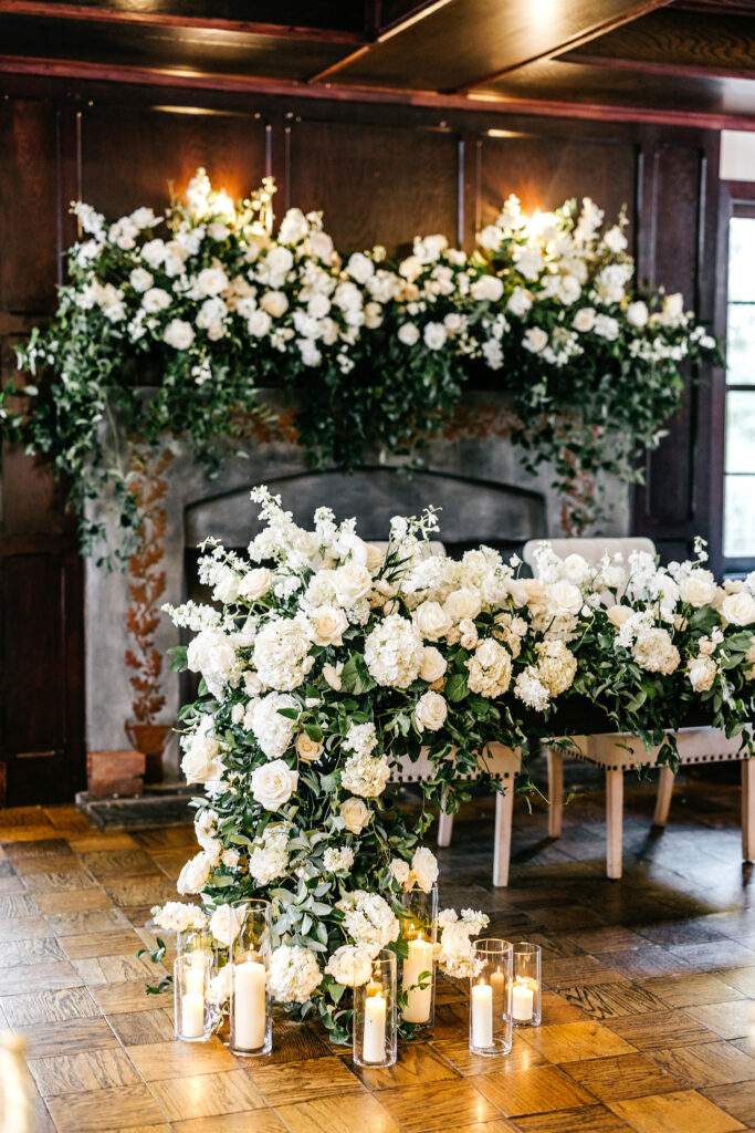 Sweetheart table decorate with all white florals and candles at Hotel du Village wedding reception