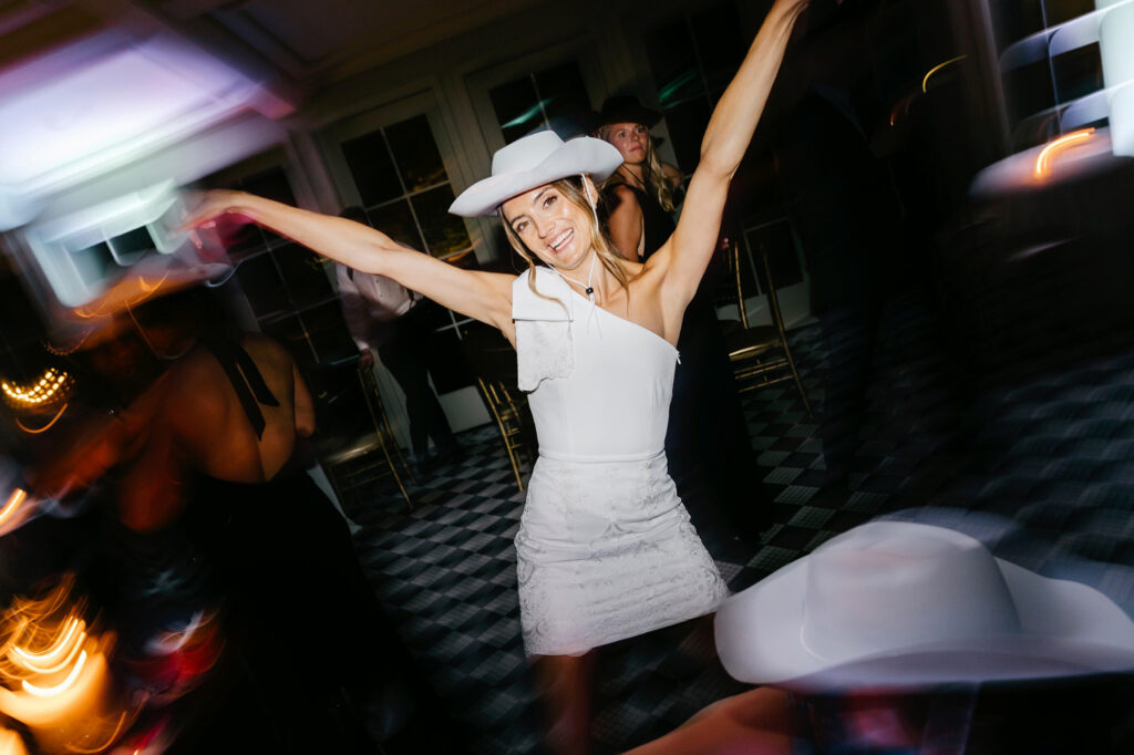 bride wearing cowboy hat at Saloon-themed wedding after party by Emily Wren Photography