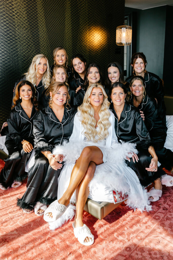 Philadelphia bride with her bridesmaids in match silk black pajamas with fur trim