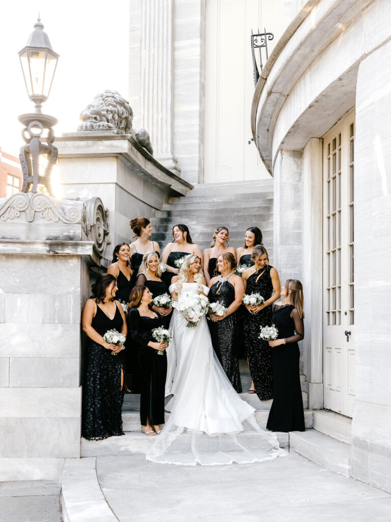 Philadelphia bride with bridesmaids at Merchant's Exchange dressed in black bridesmaid dresses by Emily Wren Photography