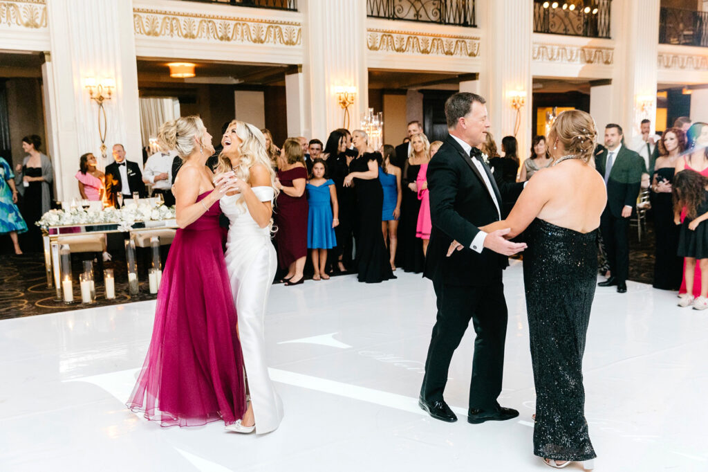 bride dances with her mother, sister and father at her Philadelphia wedding reception by Emily Wren Photography