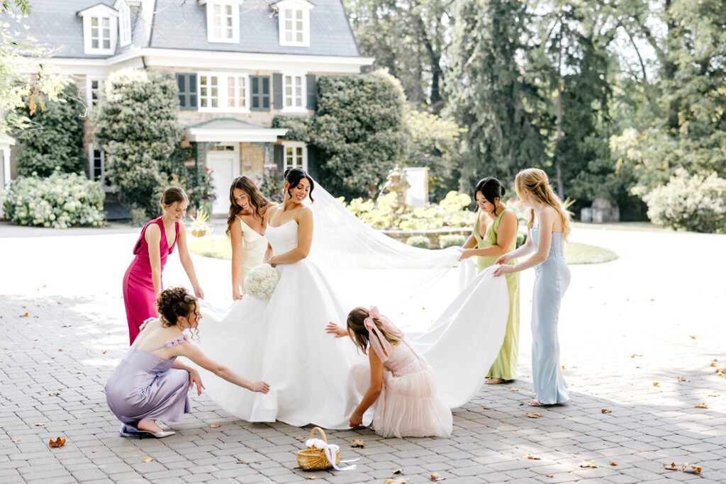 bride at The Inn at Barley Sheaf as her bridesmaids fix and fluff her wedding gown