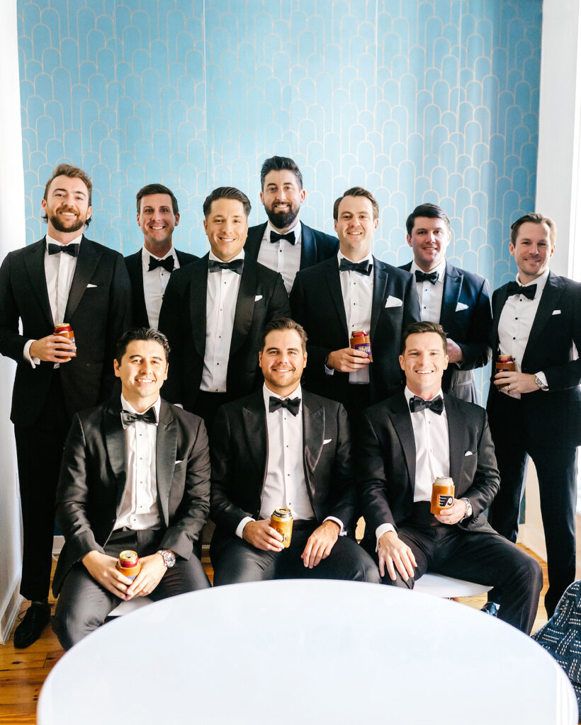 groom with his groomsmen drinking beer in coordinating sports logo koozies