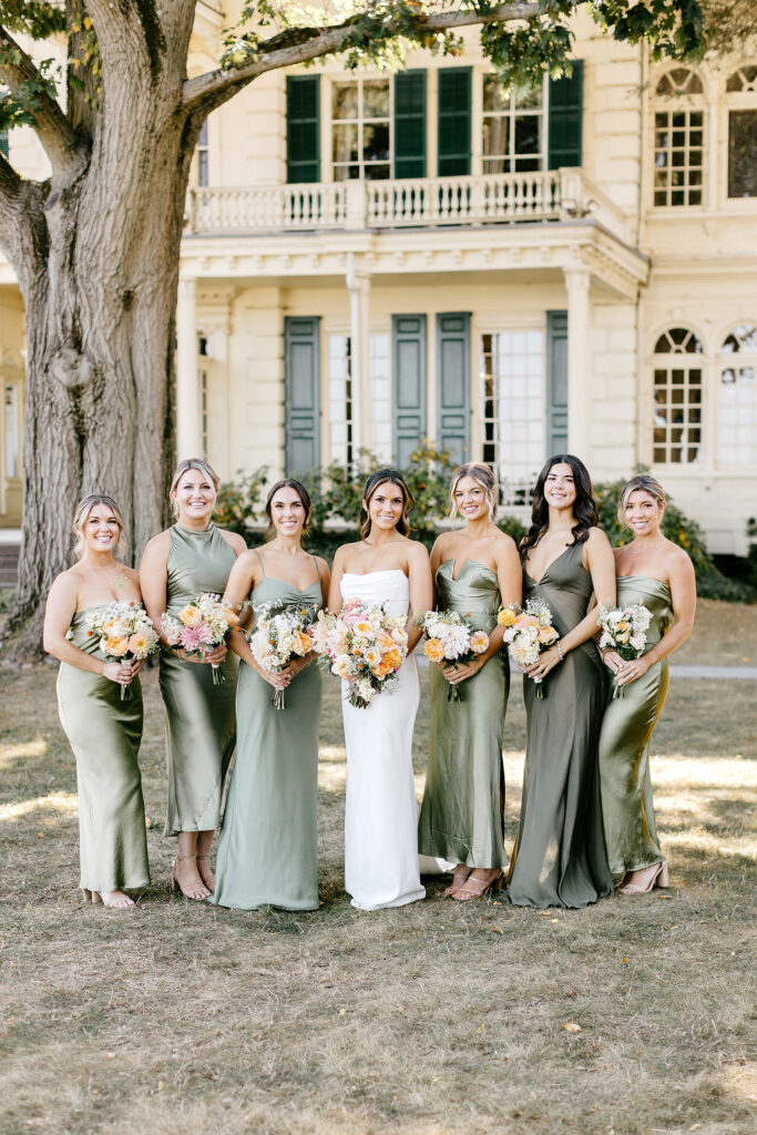 Bride with her bridesmaids in sage green bridesmaid dresses at Glen Foerd mansion.