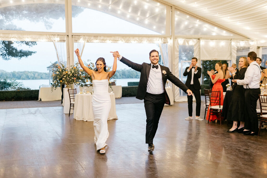 bride & groom entering their white tent wedding reception at Glen Foerd by Emily Wren Photography