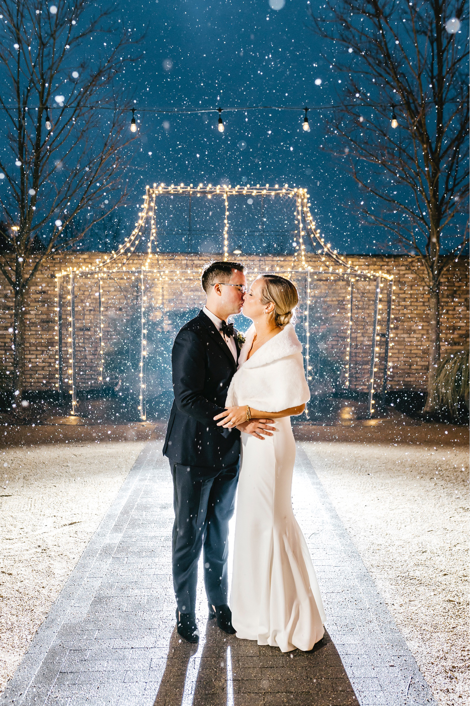 bride & groom kissing in the snow after Winter Philadelphia wedding reception by Emily Wren Photography