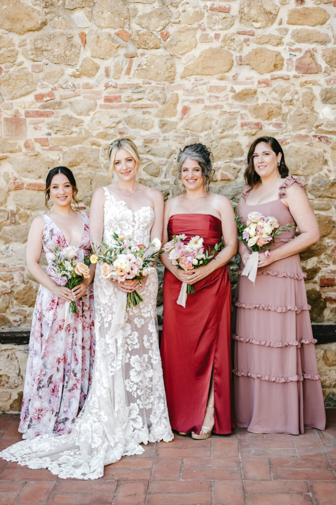 bride with bridesmaids in coordinating pink and red bridesmaid dresses