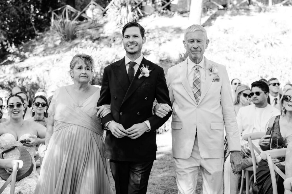 groom walking down the aisle with both of his parents