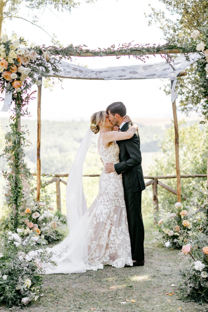 bride & grooms first kiss at their Italian summer wedding ceremony at Borgo Sant'Ambrogio