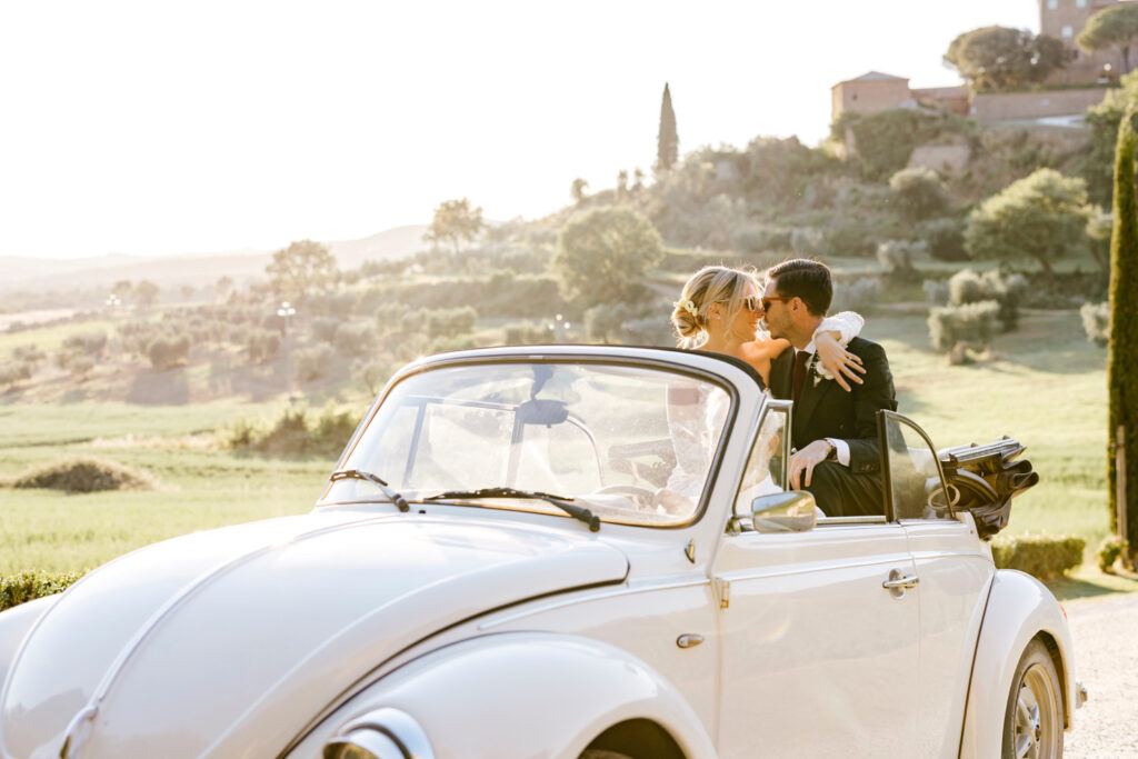 golden hour portraits of bride & groom in a vintage car by wedding photographer Emily Wren Photography