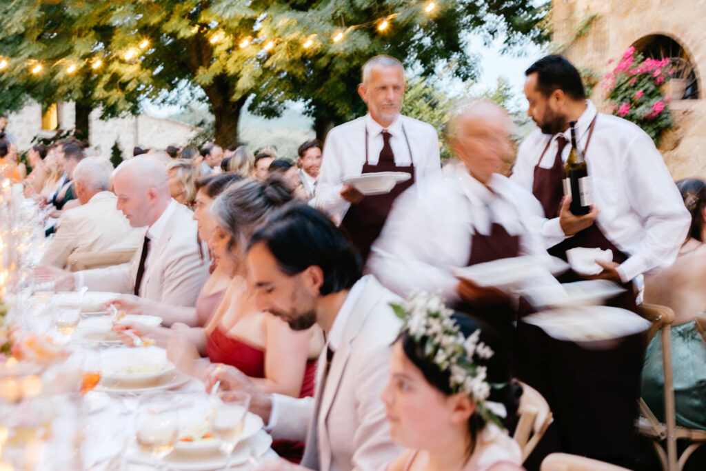 waiters serving dinner at Italian wedding reception at Borgo Sant'Ambrogio by Emily Wren Photography