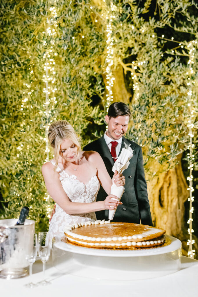 bride & groom decorating their wedding cake at their Borgo Sant'Ambrogio wedding ceremony by Emily Wren Photography