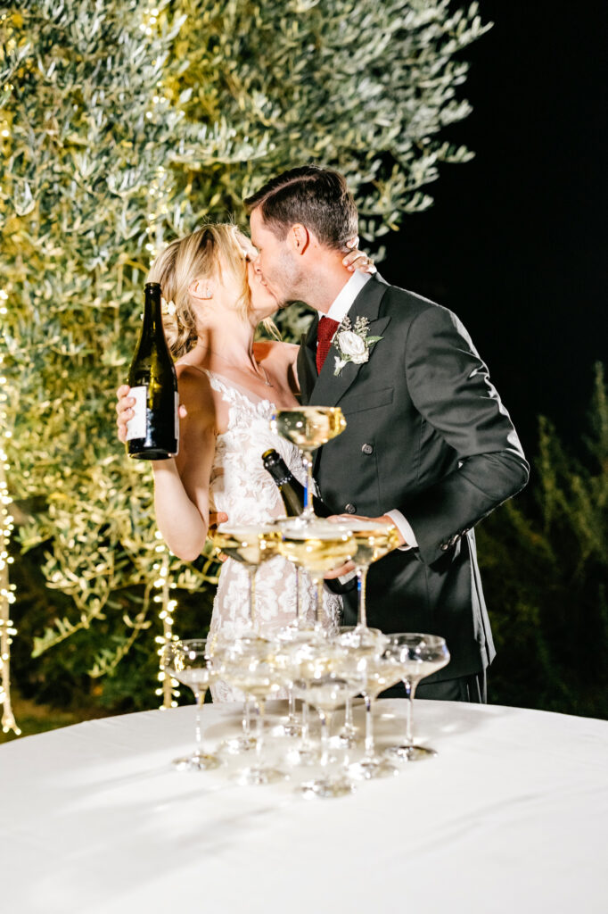 bride & groom kissing at their champagne tower by Emily Wren Photography