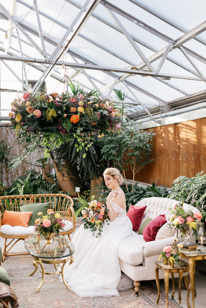 Philadelphia bride sitting in bohemian cocktail hour seating at her spring garden inspired wedding