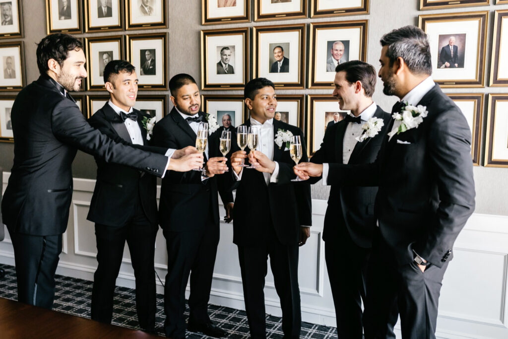Philadelphia groom toasting champagne with his groomsmen before his winter wedding day by Emily Wren Photography