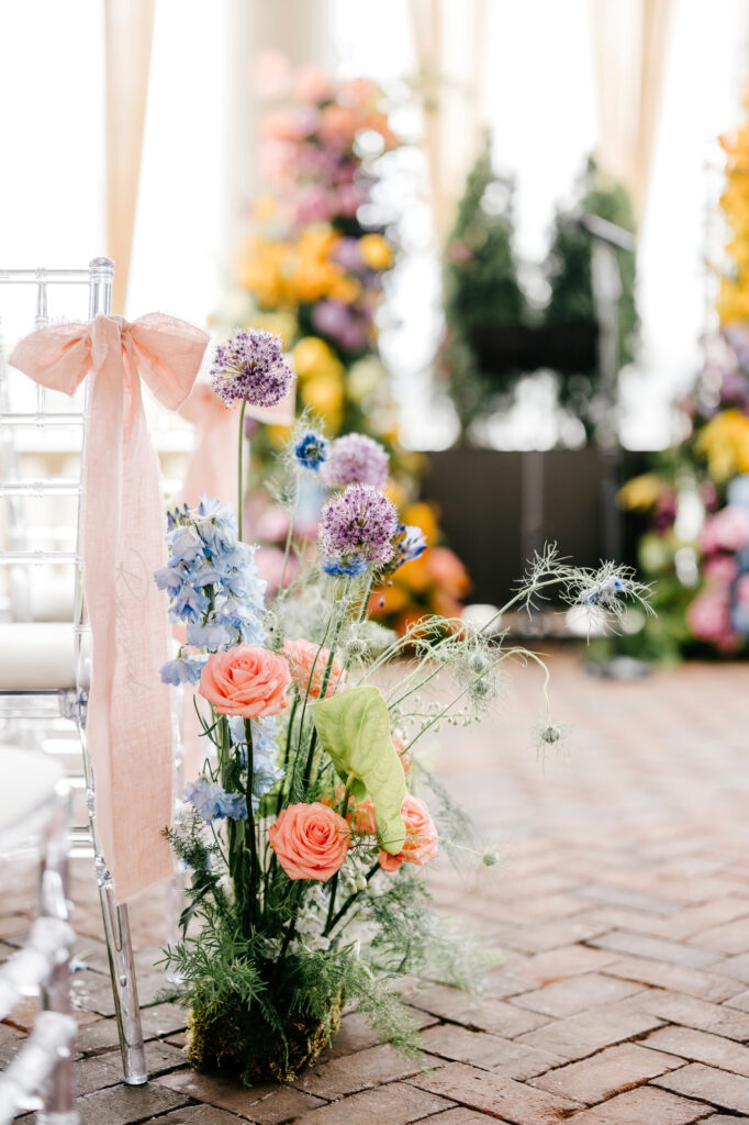 colorful garden wildflowers aligning wedding aisle with a pink bow