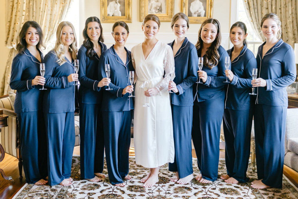 bride with her bridesmaids on the morning of her Fall wedding day in matching blue pajamas