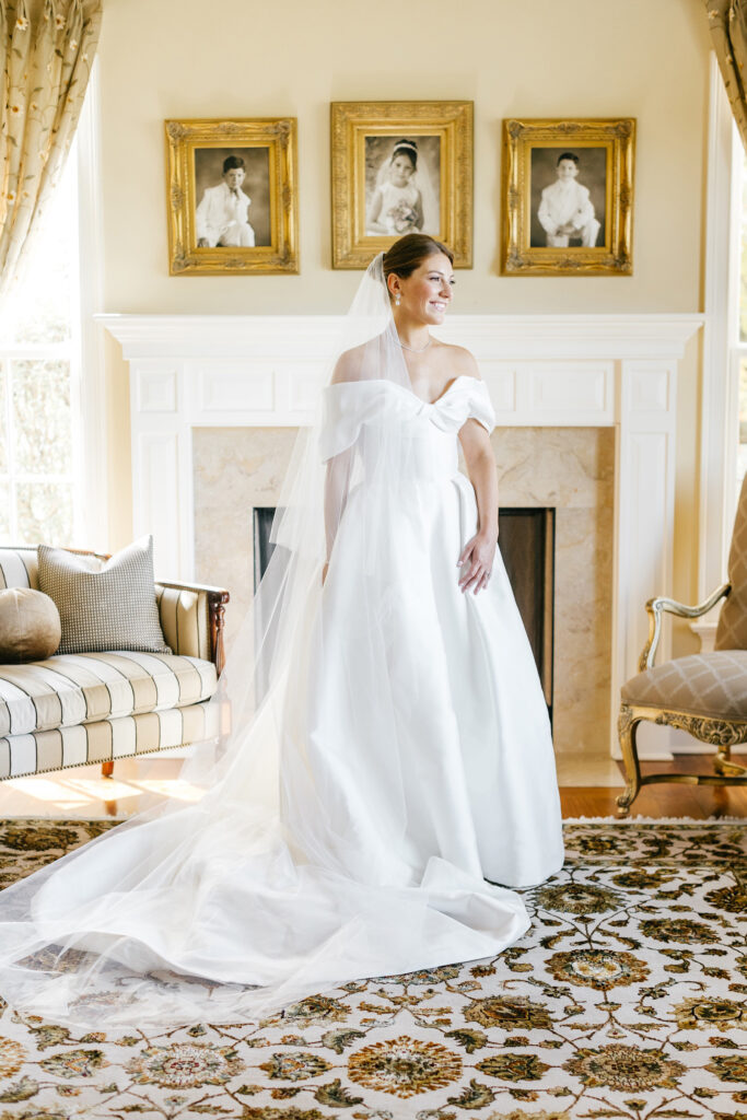 portrait of New Jersey bride in her childhood home on the morning of her wedding day, with portraits of her ancestors wedding portraits behind her
