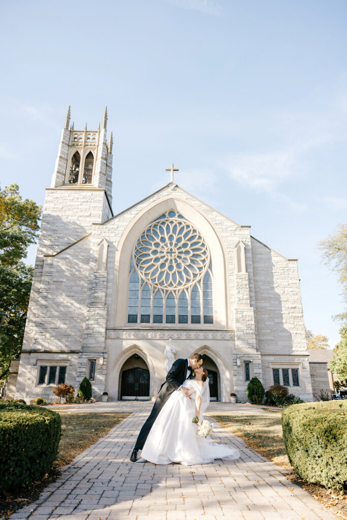 bride & groom kissing in front of their catholic ceremony church in Princeton, New Jersey