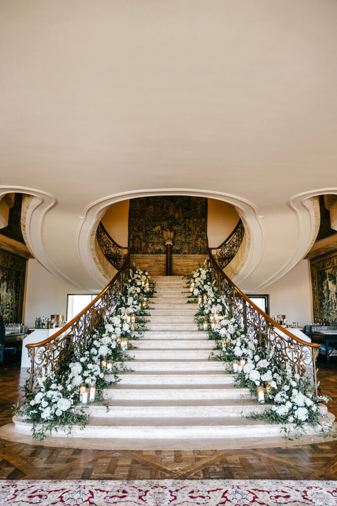 Jasna Polana staircase decorated with white florals and lush greenery