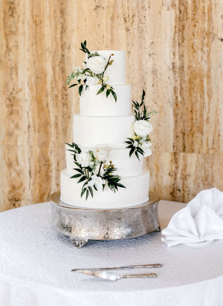 5 tier all white wedding cake decorated minimally with white roses by Emily Wren Photography