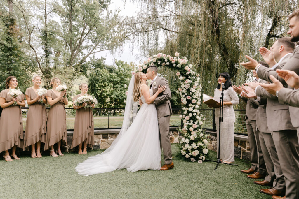 bride & grooms first kiss at their outdoor wedding ceremony in New Hope, Pennsylvania