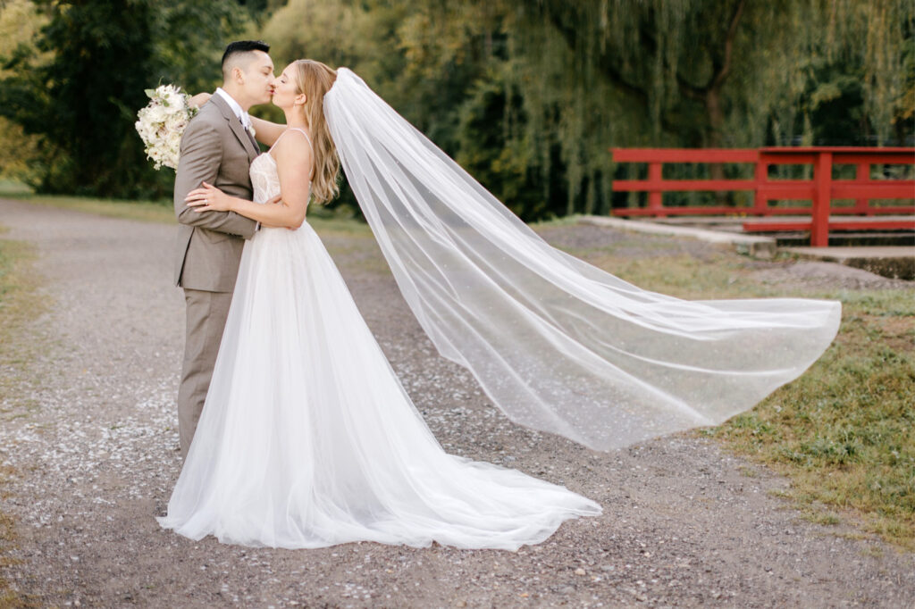 bride & groom wedding portrait as veil blows in the wind by Pennsylvania wedding photographer Emily Wren Photography