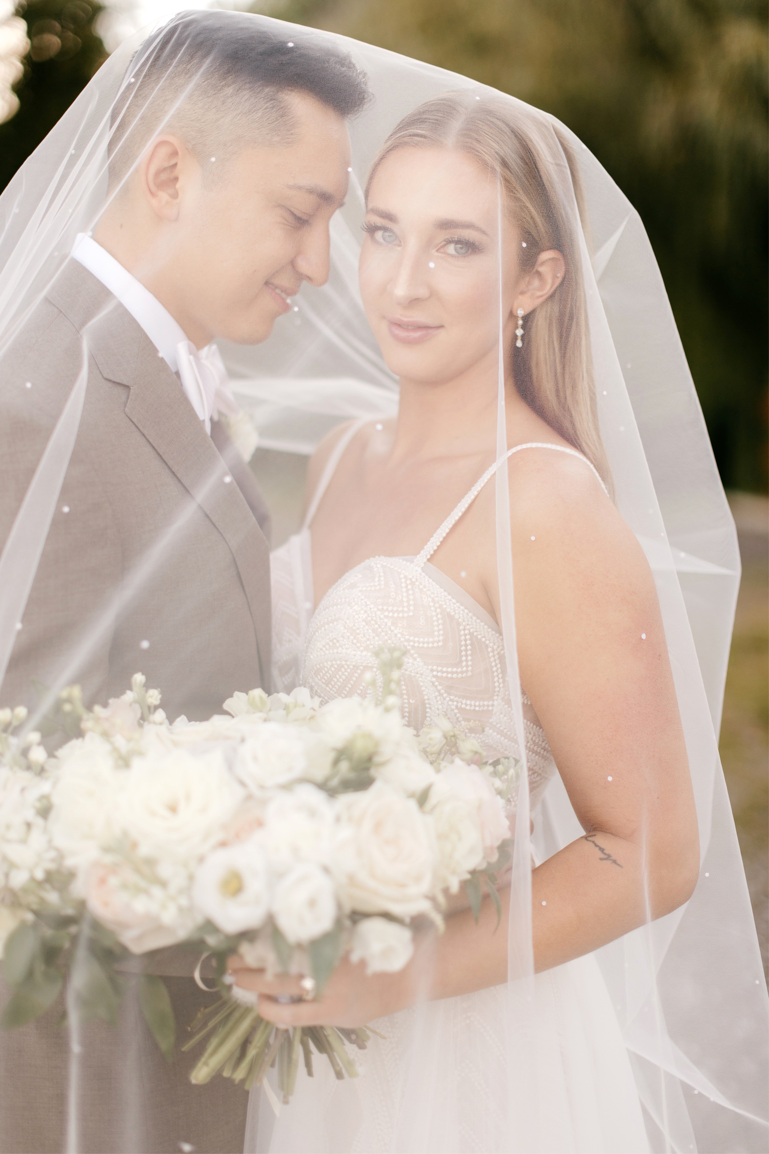 bride & groom under the veil during their wedding portrait session