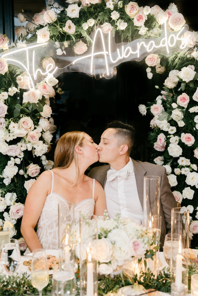 bride & groom sweetheart table with LED sign of their last name by Emily Wren Photography