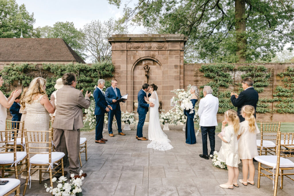 bride & groom's first kiss at their spring outdoor wedding ceremony at Tyler Gardens