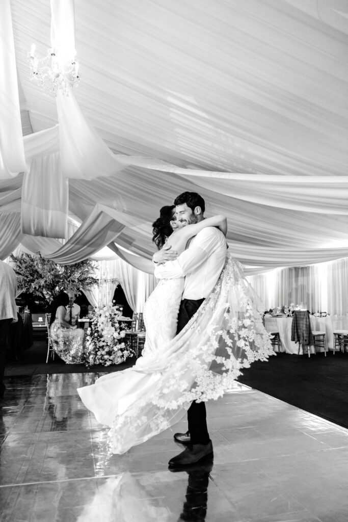 groom twirling his bride in the air at their Tyler Gardens spring wedding reception