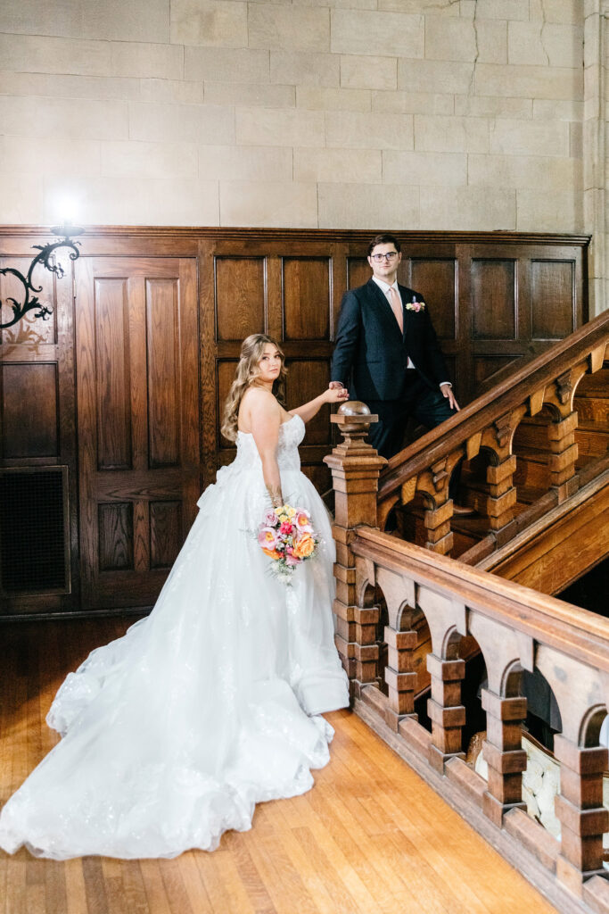 Cinematic portrait of bride & groom walking up the stairs