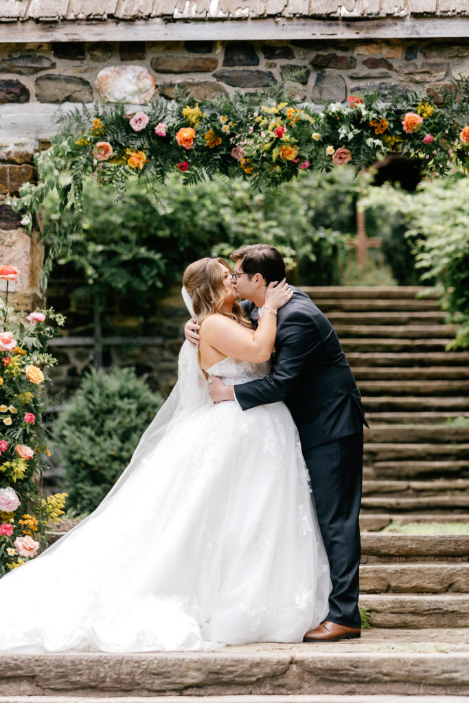 bride & groom's first kiss at their outdoor garden wedding ceremony by Pennsylvania wedding photographer Emily Wren Photography