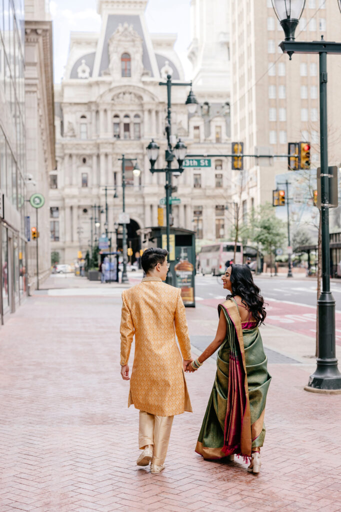 Philadelphia bride & groom walking down broad street towards City Hall by Emily Wren Photography