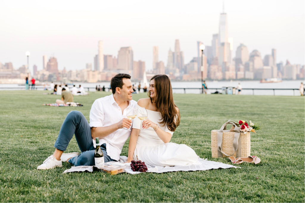 couple having a picnic at Pier A Park for their engagement photoshoot by Emily Wren Photography