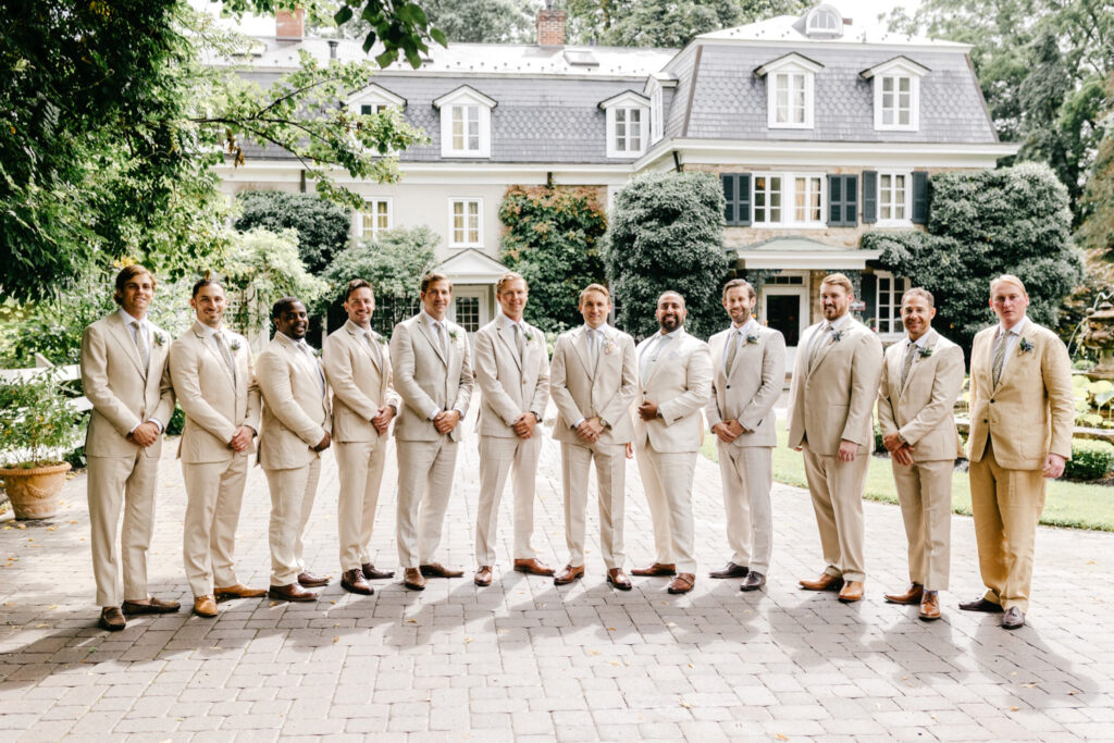Philadelphia groom with his groomsmen in beige tuxes for summer garden wedding day