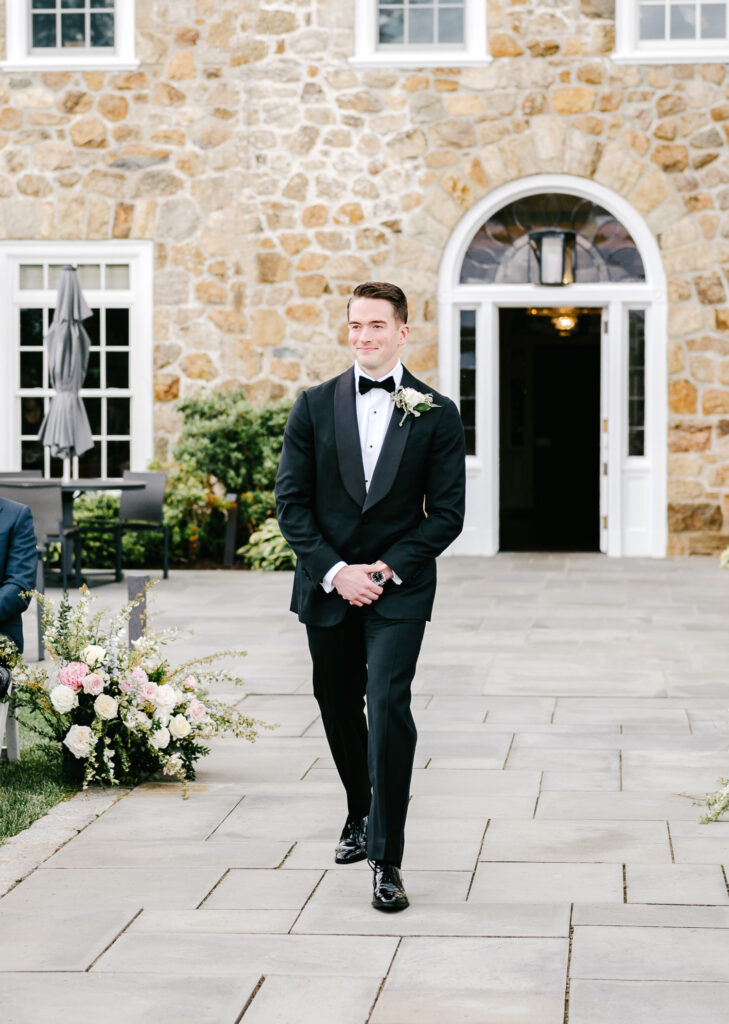 New Jersey groom walking down the aisle at his outdoor spring wedding ceremony at Fiddler's Elbow