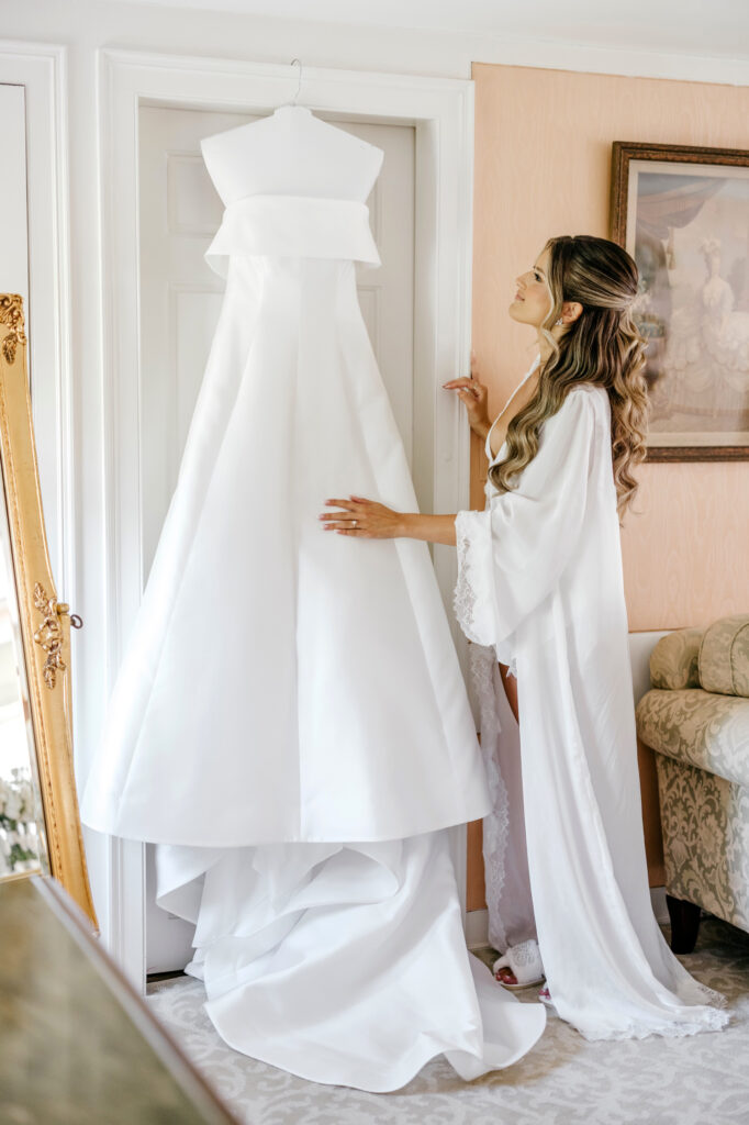 Philadelphia bride admiring her wedding dress before she gets ready for her summer wedding day