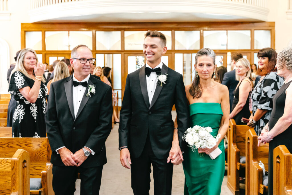 groom walking down the aisle at his wedding ceremony at Our Mother of Good Counsel Church