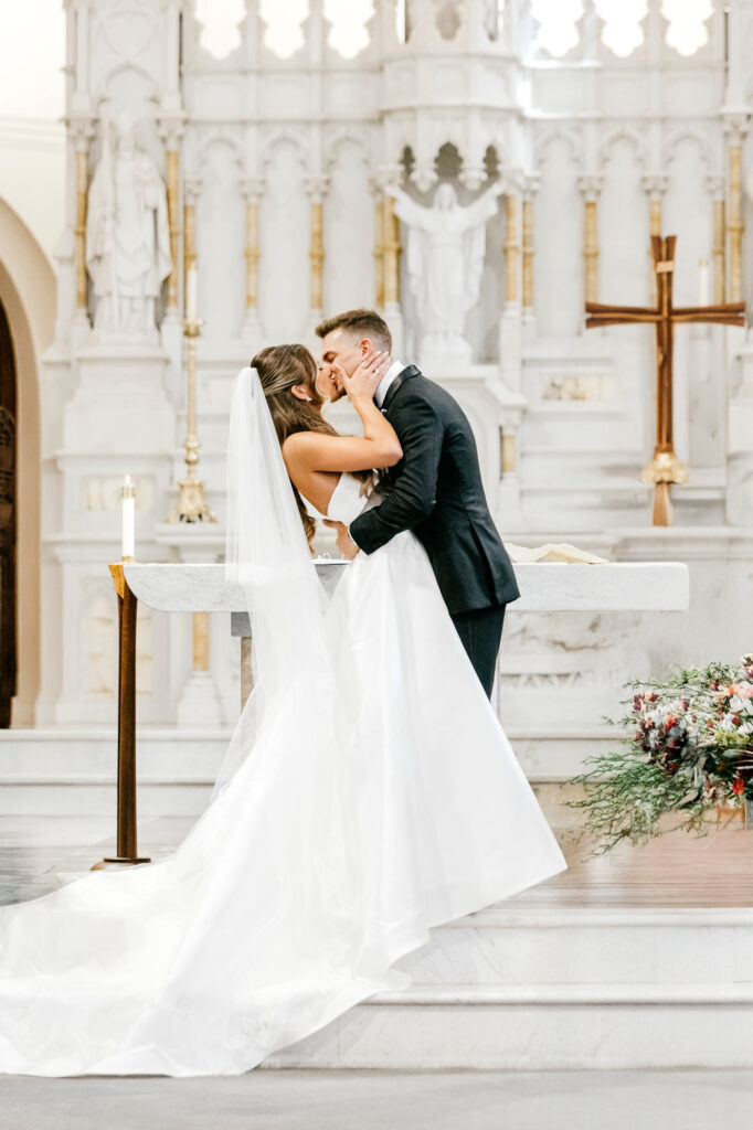 bride & grooms first kiss at their Bryn Mawr wedding ceremony at Our Mother of Good Counsel by Pennsylvania wedding photographer Emily Wren Photography