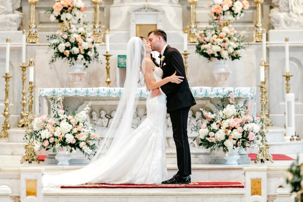 bride & grooms first kiss at their summer wedding ceremony at St. Peter's Church