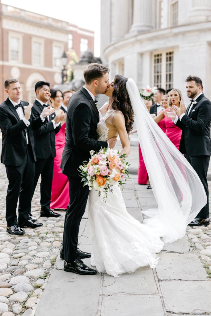 bride and groom kissing in front of their wedding party in Old City Philadelphia