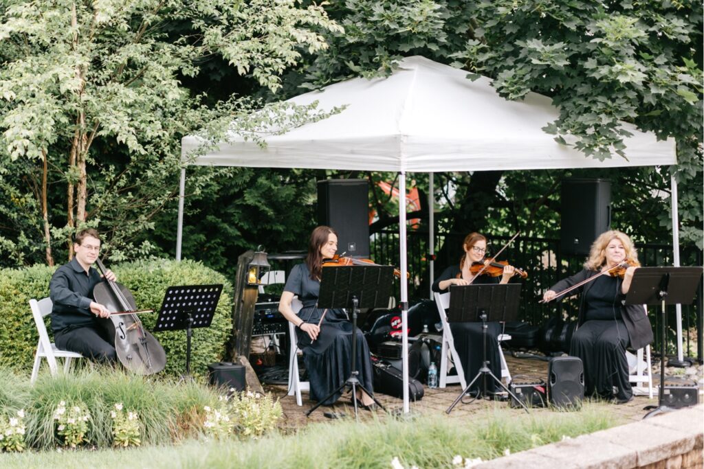 Sweet Harmony performing at an outdoor lakeside wedding ceremony by Emily Wren Photography